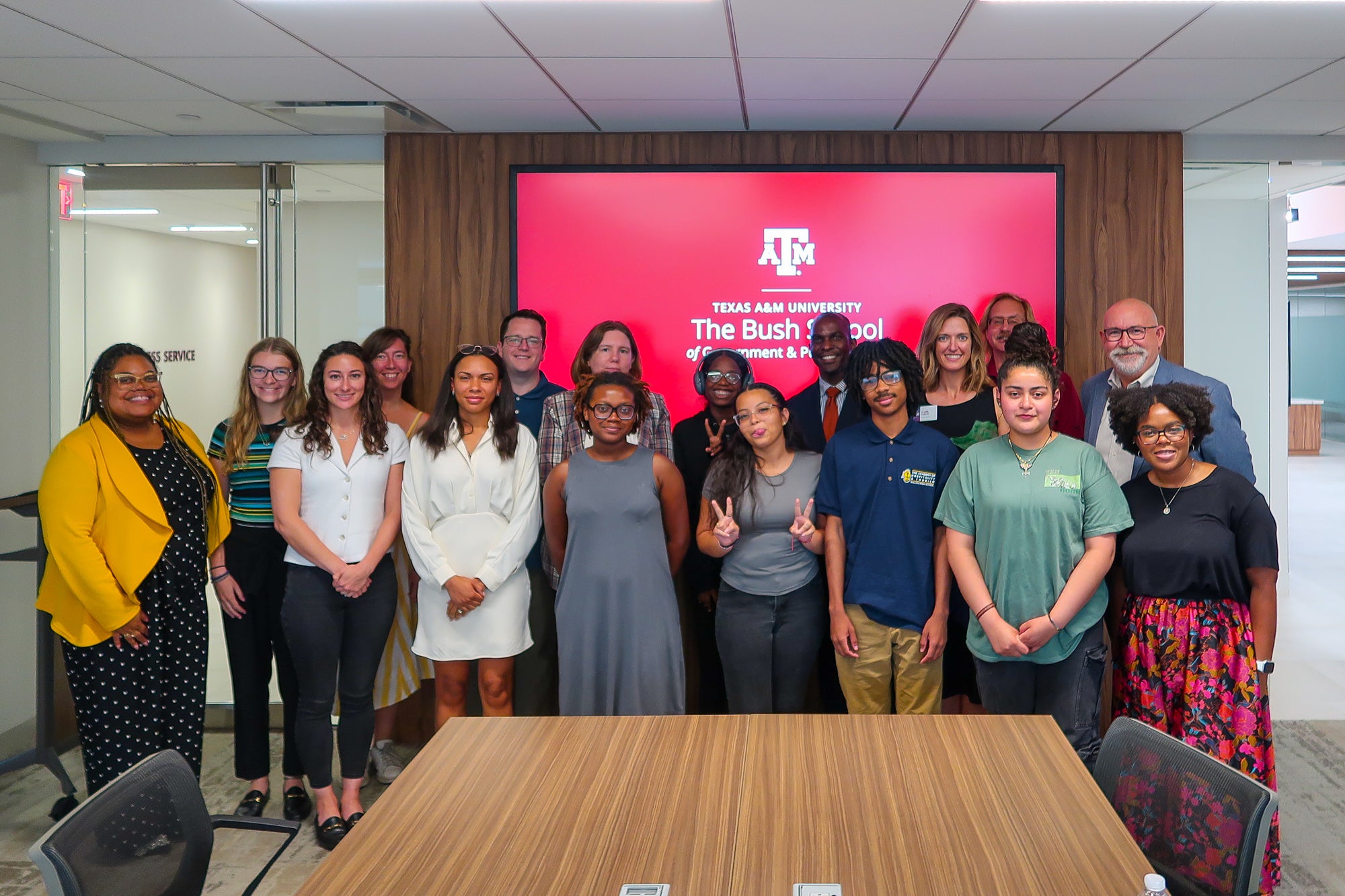 The 2024 CRI cohort stands in front of a screen with the the Texas A&M Bush School logo