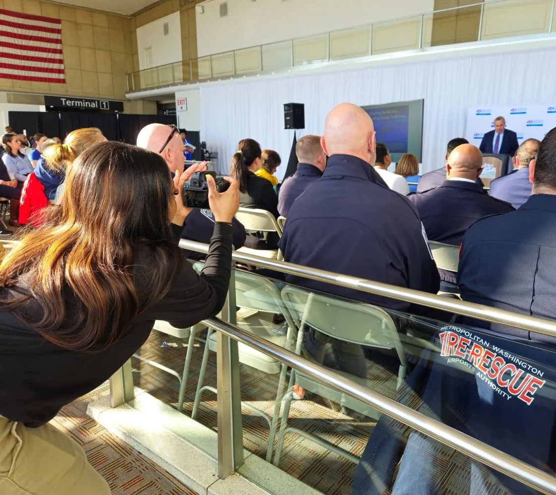 A Black high school student shoots photos with a DSLR camera at the MWAA Human Trafficking Event in the historical terminal at National Airport