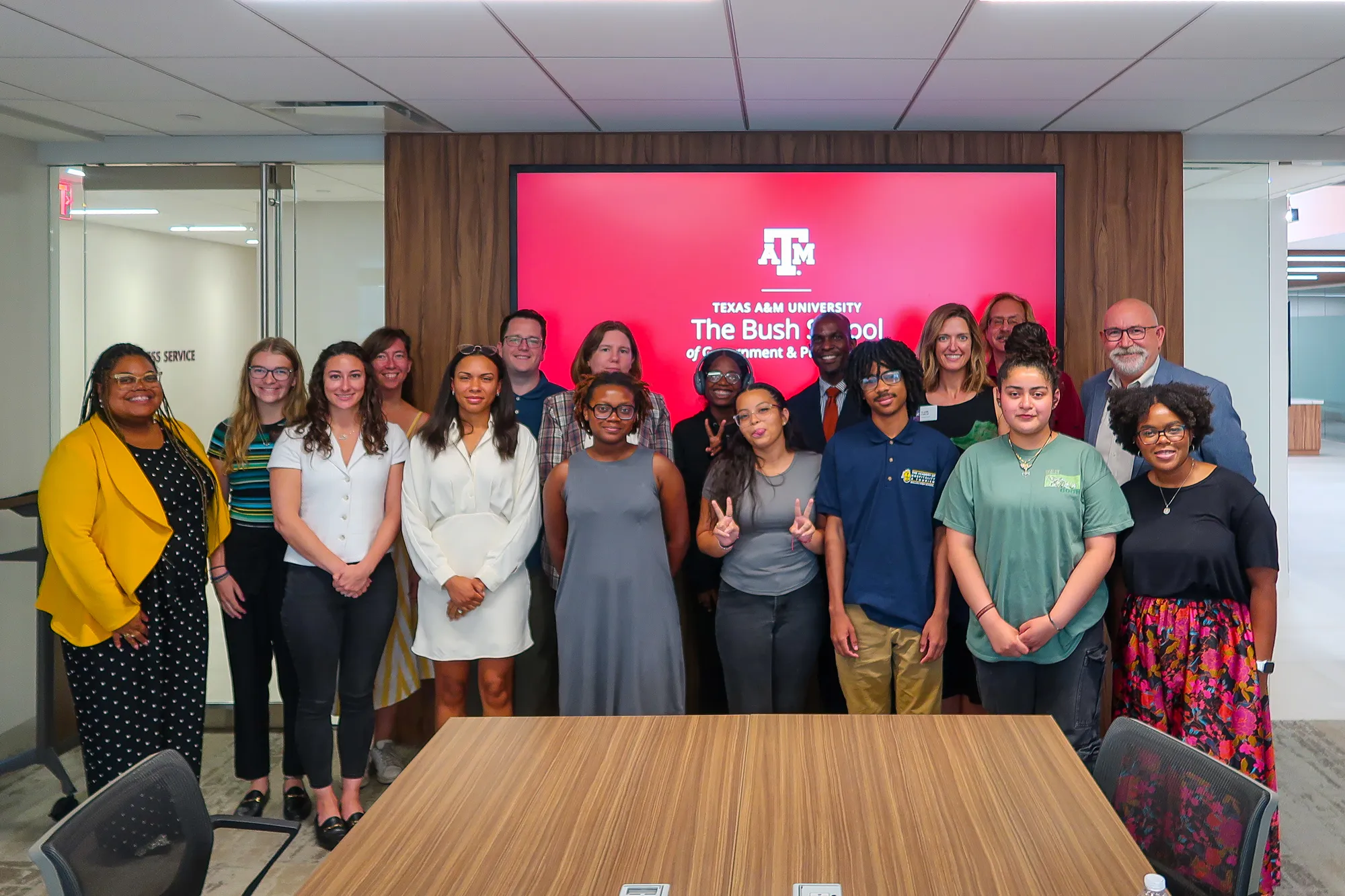 The 2024 CRI cohort stands in front of a screen with the the Texas A&M Bush School logo