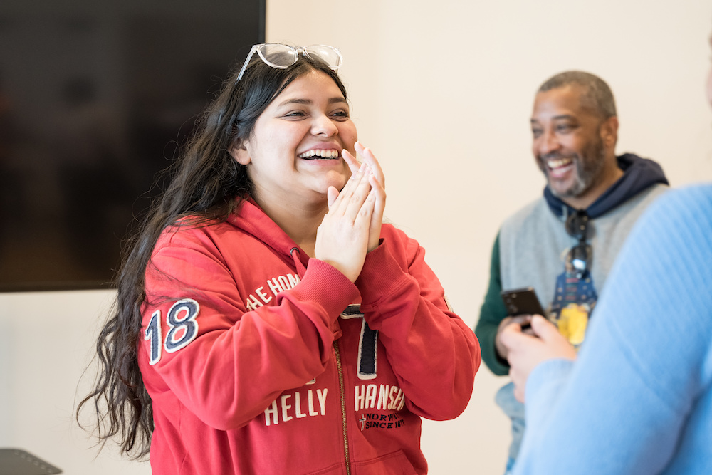 A young Latina student with long dark hair and a red hoodie laughs during the NEXTDC Backyard Bound field trip