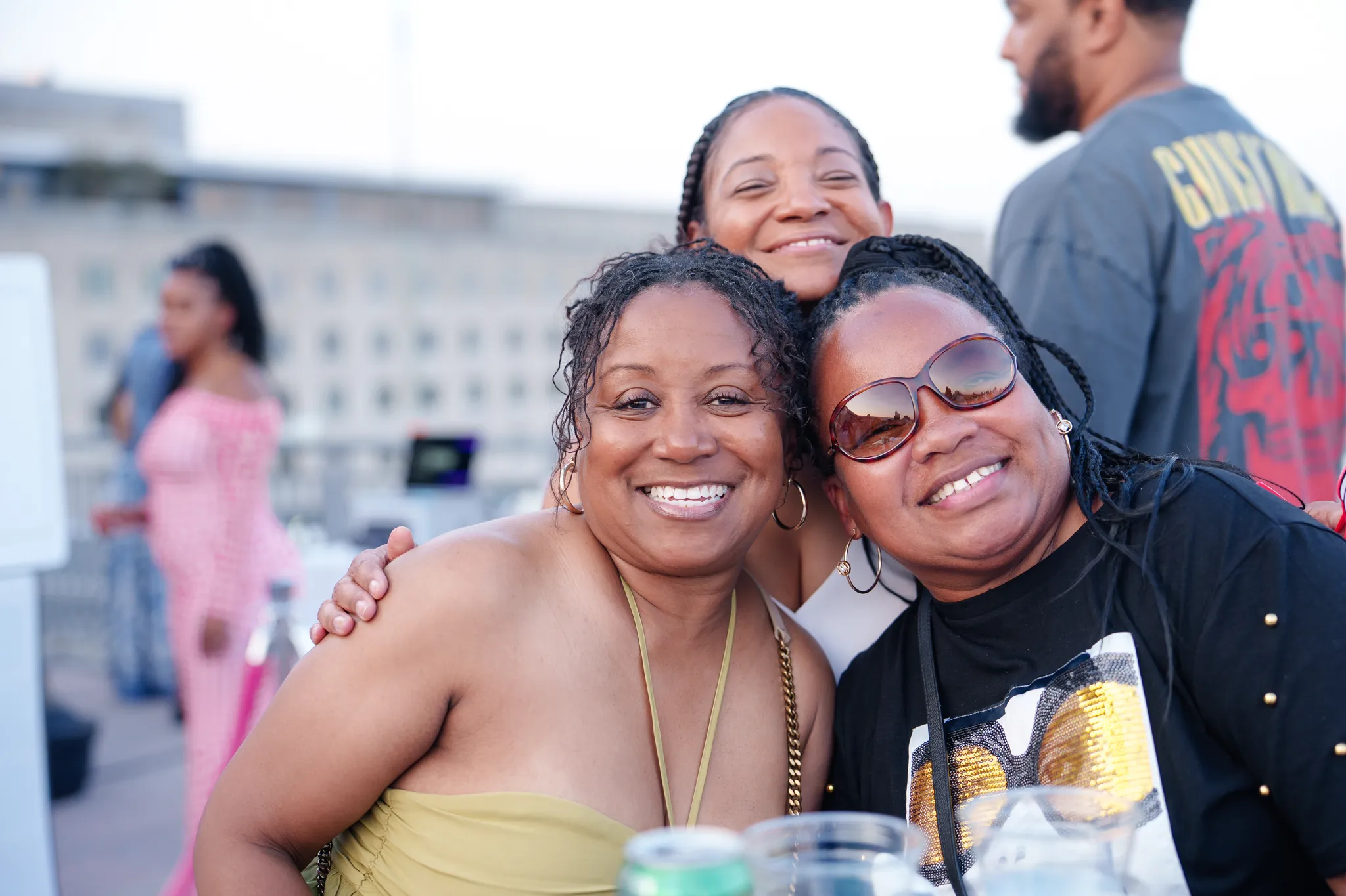 Three Black women smile for the camera at the July 4th VIP Celebration
